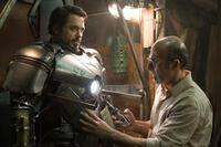 Tony Stark (Robert Downey Jr., left) is fitted into his Mark I armor by Yinsen (Shaun Toub) in “Iron Man.” 