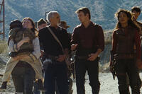 From left to right are crewmembers of "Serenity", Mechanic Jewel Staite as Kaylee holds a local village boy while village elder Ron Glass as Shepard Book.