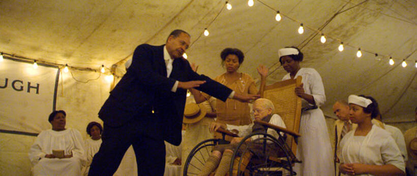 A healing preacher (Lance E. Nichols) seeks to help Benjamin (Brad Pitt) who has been brought to the convocation by Queenie (Taraji P. Henson) in "The Curious Case of Benjamin Button."