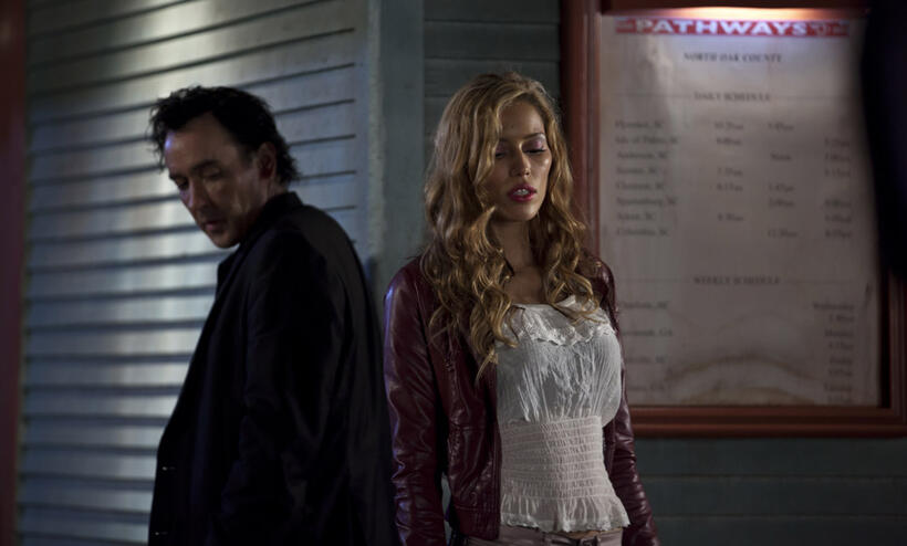 John Cusack as Jack and Rebecca DaCosta as Rivka in "The Bag Man."