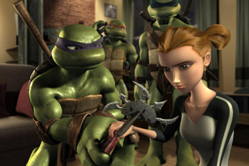 Donatello shows April the Obsidian disc as Michelangelo and Leonardo look on in "Teenage Mutant Ninja Turtles."