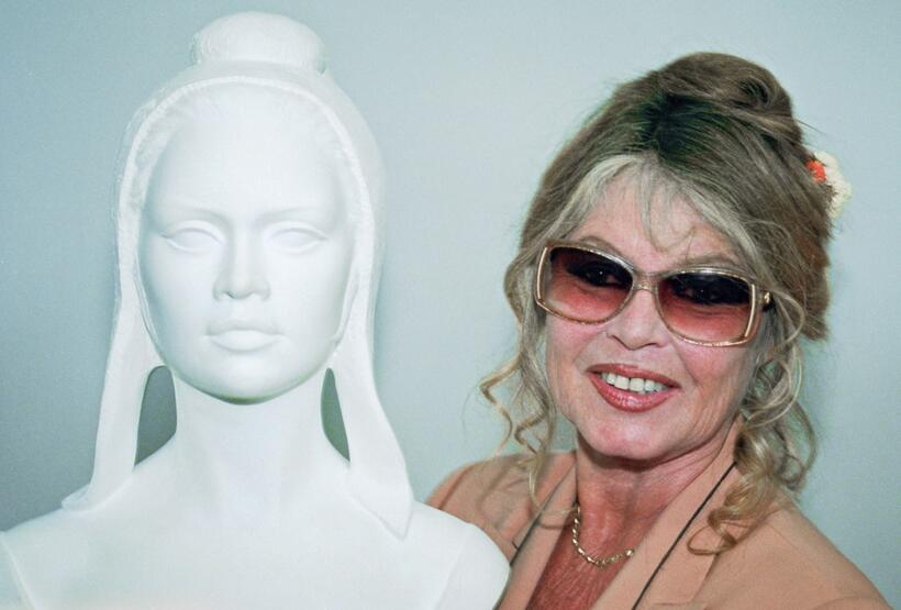 Brigitte Bardot next to the Bust of Marianne the symbol of the French Republic.