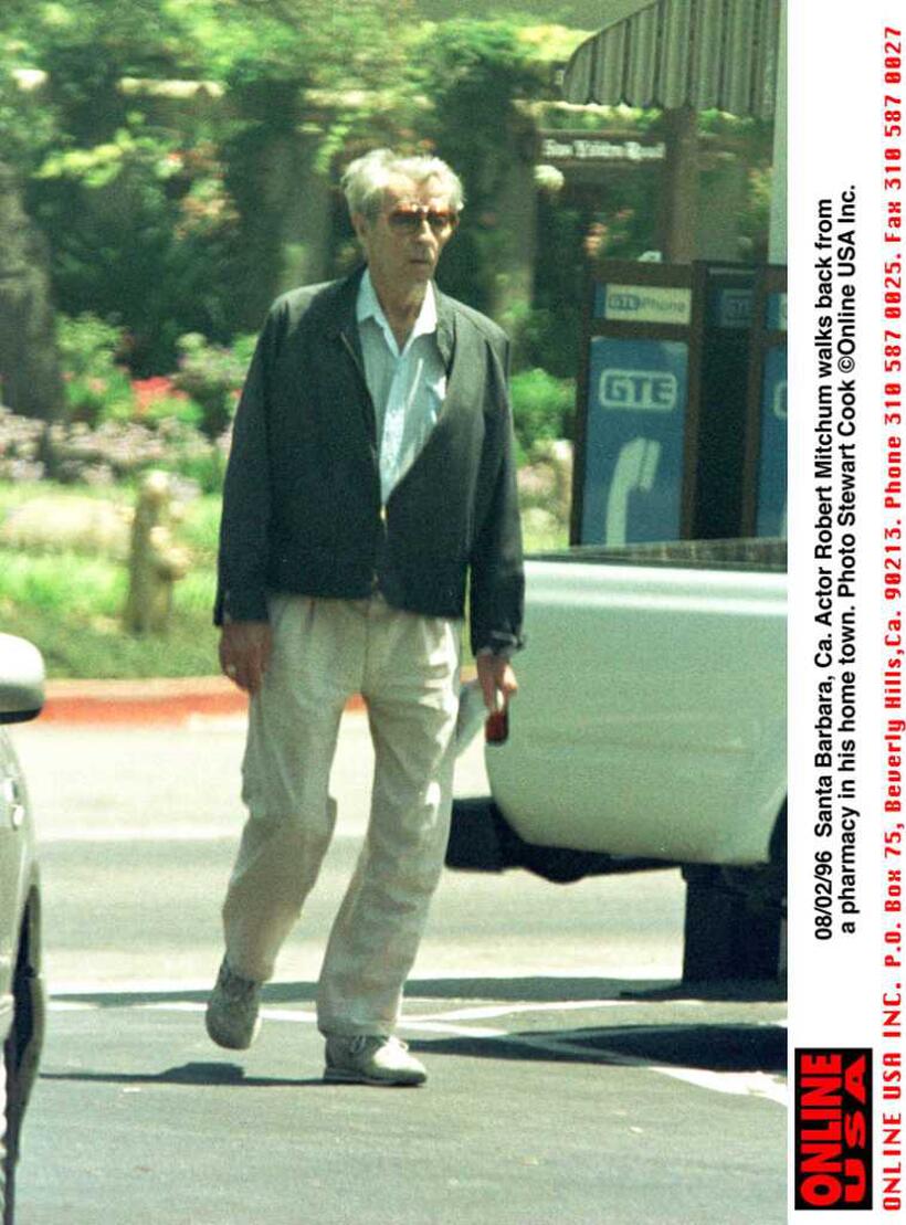 Robert Mitchum walks to his car after visiting his local pharmacy.