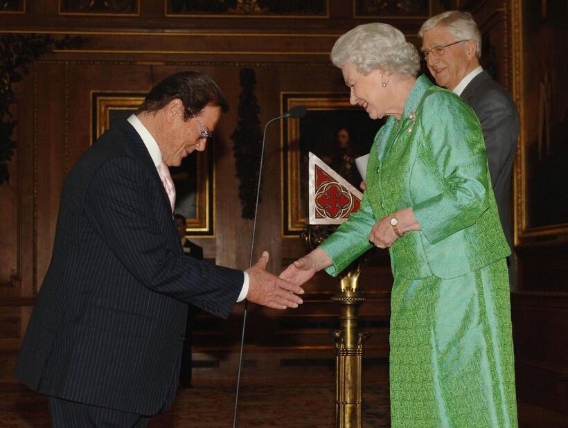 Roger Moore is greeted by Queen Elizabeth II at the Help the Aged "Living Legends" award ceremony.