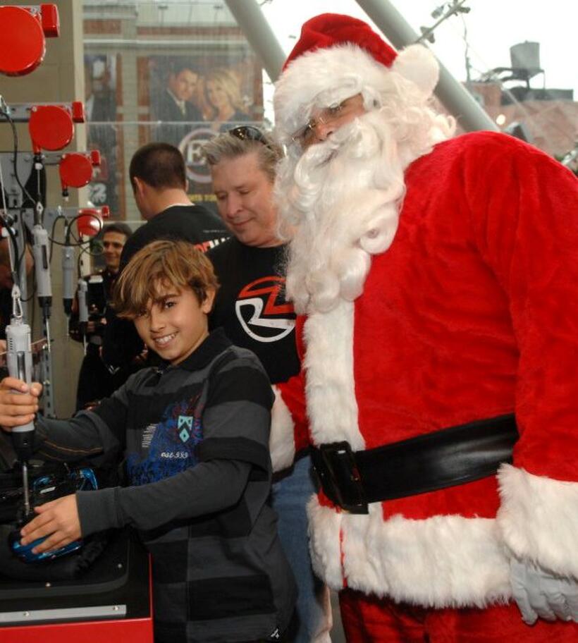 Jansen Panettiere and Santa Clause at the Ridemakerz unveiling of a toy Mini to the Boys and Girls Club.