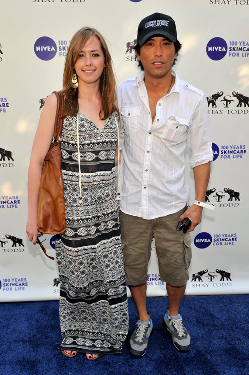 Peter Shinkoda and Guest at the "Goodbye cellulite, hello bikini" poolside party in California.