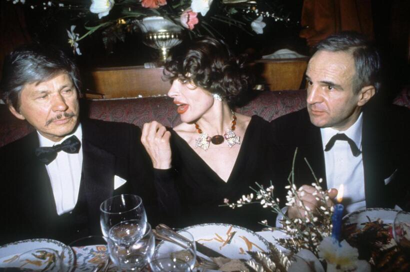 Francois Truffaut, Charlies Bronson and French actress Fanny Ardant at a dinner event in Paris.