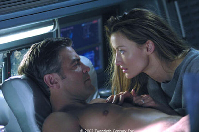 Chris Kelvin (George Clooney) and Rheya (Natascha McElhone) share a passionate moment amid the turmoil surrounding her shocking appearance aboard a space station.